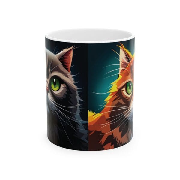 The Angry Cats Coffee Mug 11oz showcases a bold design with an artistic illustration of two cats, one grey and the other orange, both with green eyes, split down the middle.