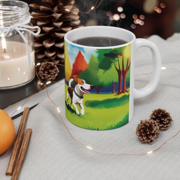 The Playful Dog Coffee Mug 11oz, featuring an illustration of a dog in a forest, is filled with steaming coffee and placed on a table next to pinecones, a candle, cinnamon sticks, and an orange.