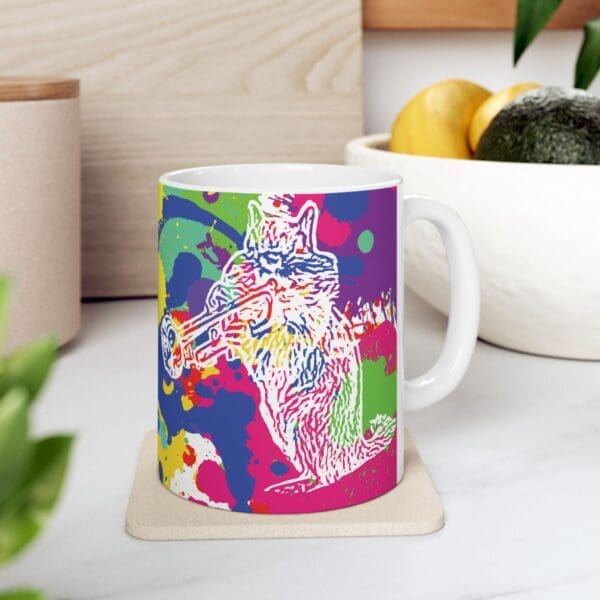 The Splash Chipmunk Coffee Mug showcases a colorful, abstract illustration of a cat playing a trumpet, set against vibrant splashes of paint in the background on a white surface.