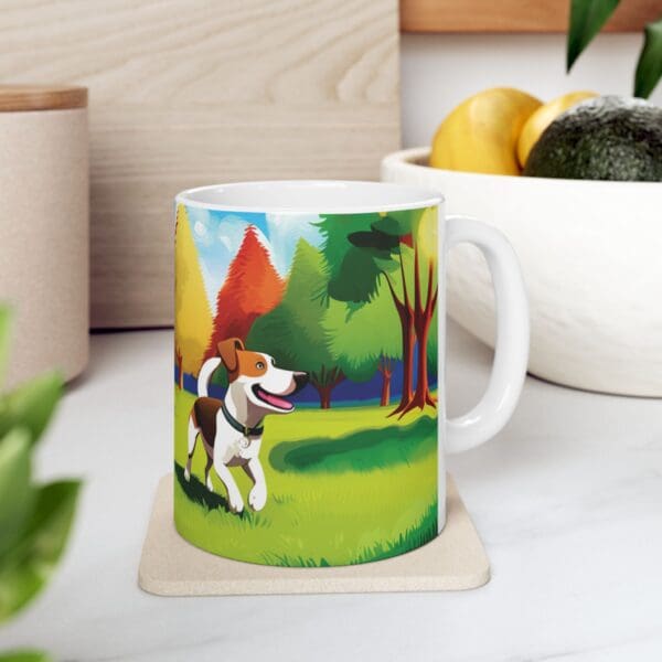 A Playful Dog Coffee Mug 11oz, adorned with an illustrated scene of a dog frolicking in a vibrant park, is placed on a coaster. In the background, a bowl of fruit can be seen.