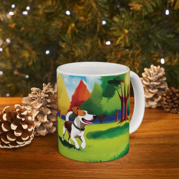 The Playful Dog Coffee Mug 11oz, featuring a cartoon dog in a forested landscape design, is placed on a wooden surface surrounded by pinecones, with blurred Christmas lights and tree branches in the background.