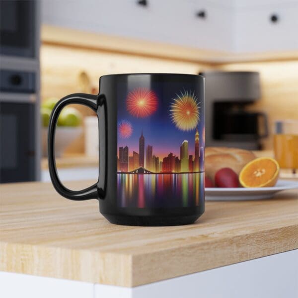 A City Skyline Fireworks Coffee Mug sits on a wooden kitchen counter. The background shows a plate with sliced fruit and kitchen appliances.