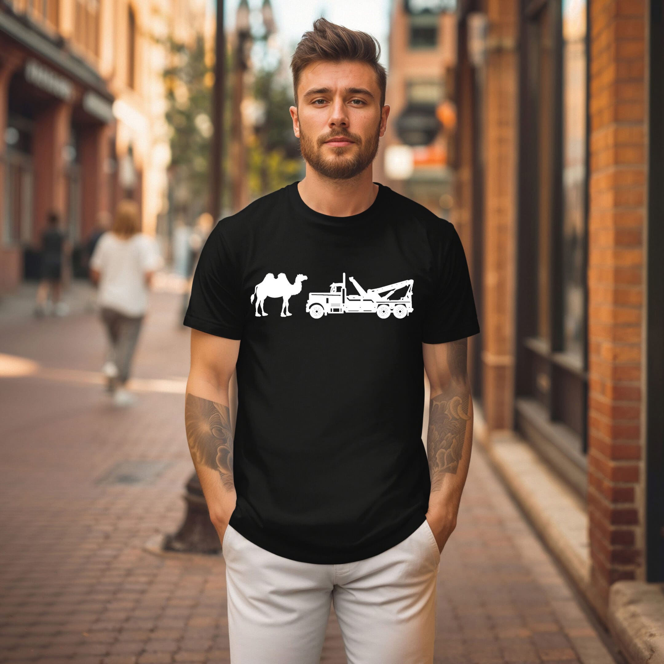 A man stands on a city sidewalk wearing the Camel Tow T-shirt, which features a graphic of a camel and a tow truck.