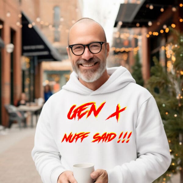 A bald man with glasses is smiling and holding a cup while wearing the Gen X Hoodie, which features the bold, colorful text "GEN X NUFF SAID!!!" on a white background. The scene is set in an outdoor cafe with casually dressed people in the background.