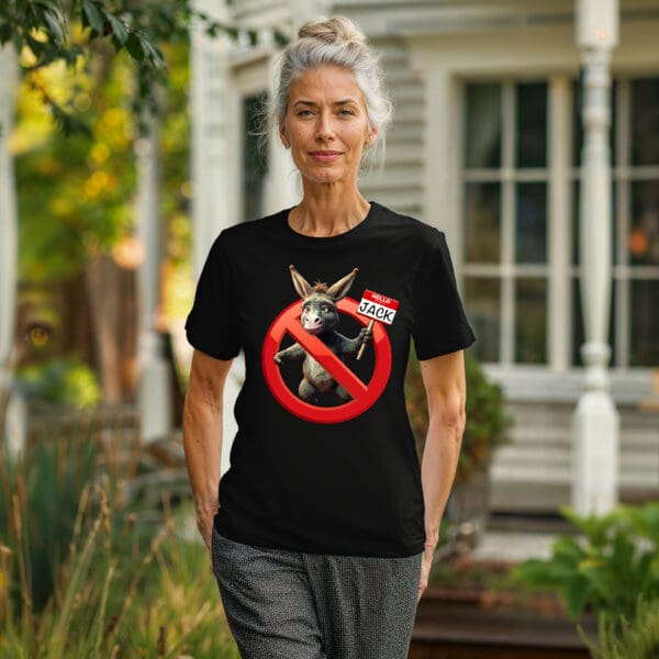 Woman standing outside a house, wearing a black "Don't Be A Jack Ass" t-shirt featuring a crossed-out donkey and a nametag reading "Hello, my name is Jack.