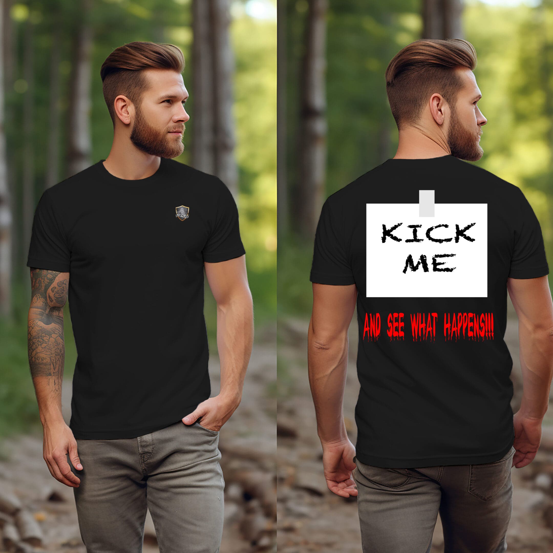 A man stands in a wooded area wearing a Kick Me T-Shirt. The back of his shirt has a large sign that reads, "KICK ME AND SEE WHAT HAPPENS!!!" written in bold and red letters.