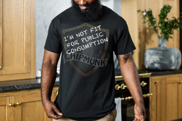 A man with a beard is wearing an "I'm Not Fit for Public Consumption" shirt—a statement fashion humorous top—in black, with the word "CHIPMUNK" underneath, while standing in a kitchen.