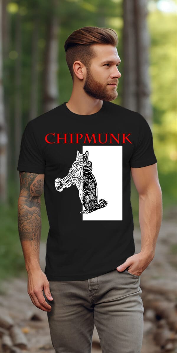 A person with tattoos and a beard walks outdoors against a forest backdrop, wearing a black Chipmunk T-Shirt featuring a sketch of an anthropomorphic chipmunk holding a trumpet.