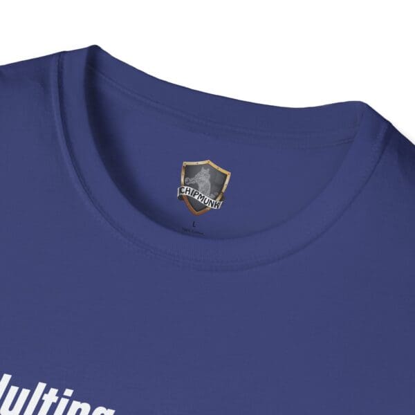 Close-up of a blue T-shirt with the name "Adulting 1-Star Review T-Shirt" beneath a shield logo at the neckline.