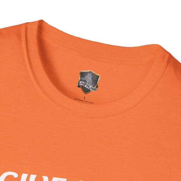 Close-up of an orange "Give Me The Tips T-Shirt" with the label "Chipmunk" under the neckline. The text on the shirt is partially visible.