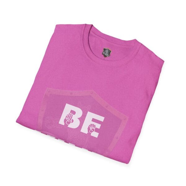 Folded pink t-shirt featuring the "Be Kind in Sign Language" design with two small peace signs inside a shield outline.