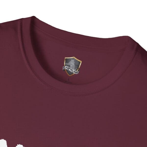 Close-up of a maroon shirt displaying a label with a shield design and the text "Camel Tow" below it.