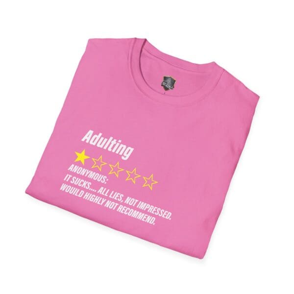 A pink t-shirt featuring the "Adulting 1-Star Review T-Shirt" design. Text reads: "Adulting" with one out of five stars. Below: "Anonymous: It sucks... all lies. Not impressed. Would highly not recommend.