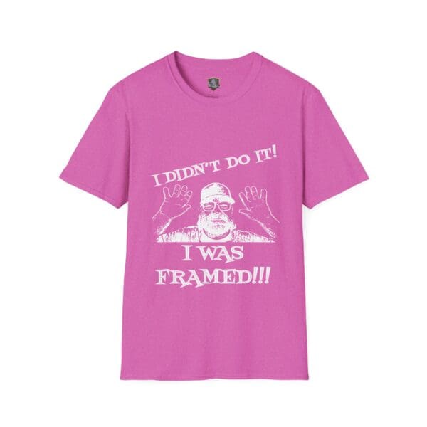 Pink T-shirt featuring an illustrated man raising his hands. Caption reads: "I didn't do it! I was framed!!!" Officially known as the George the Roadie's Iconic Icebreaker T-Shirt.