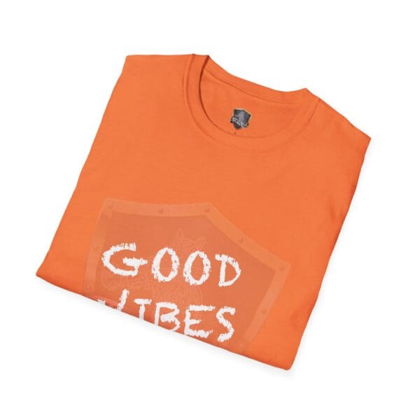 Folded orange Good Vibes Only Shirt with a "Good Vibes" print and a shield-like design on the front.