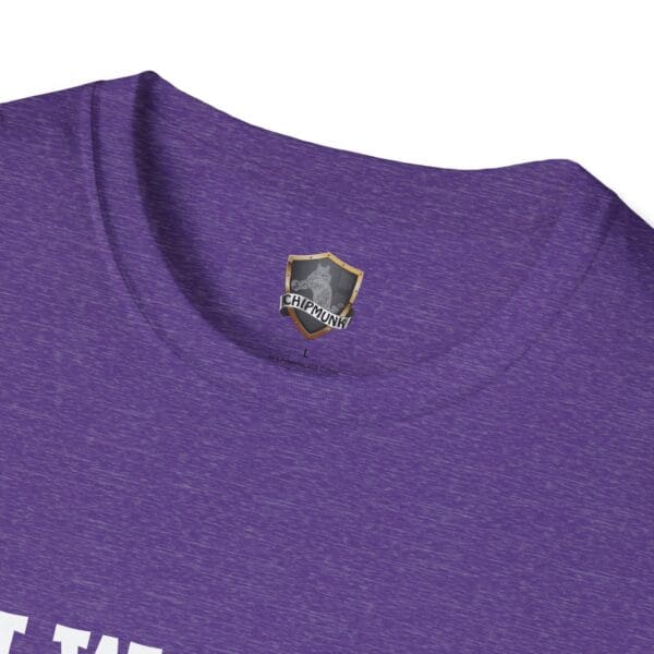 Close-up of the collar area of the "I Would Cuddle You So Hard" purple t-shirt, showcasing a small logo with a shield design.