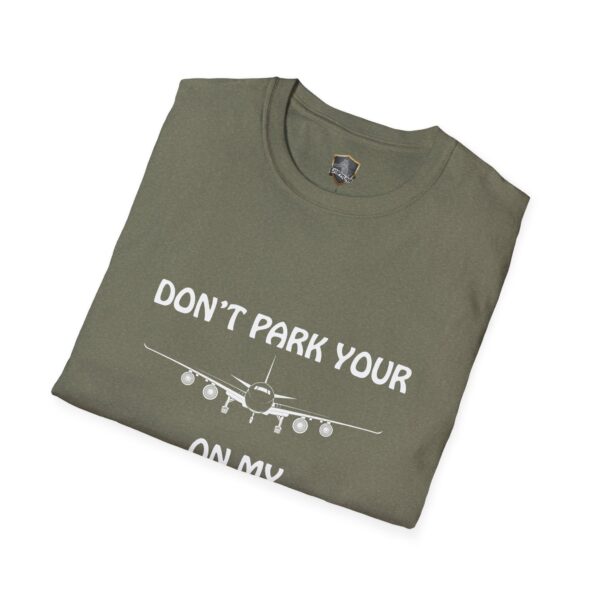 A folded T-shirt in olive green, featuring the graphic of an airplane and the text "DON'T PARK YOUR PLANE ON MY DINGY.