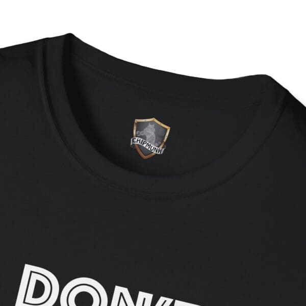 Close-up of a black t-shirt's neck displaying a "Chipmunk" logo label inside, with visible white text starting with "DON'T BE A..." on the front of the shirt.