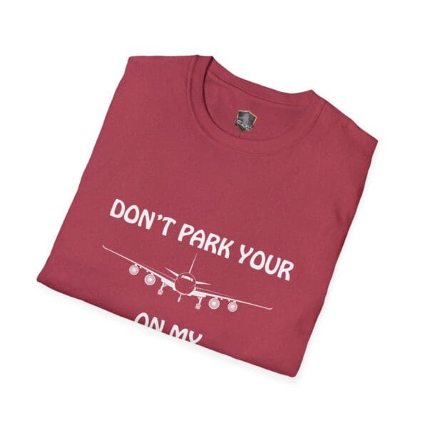 A folded red T-shirt featuring the phrase "DON'T PARK YOUR" above an airplane graphic with "ON MY" below it, from the "Don't Park Your Plane On My Dingy" collection.