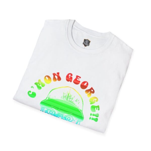 A folded C'Mon George!! Retro Rainbow Roadie T-Shirt features colorful text and a graphic of a man wearing glasses and a hat.