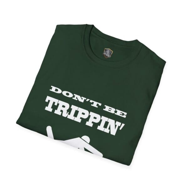 A folded green "Don't Be Trippin'" T-shirt featuring a graphic of a person falling.