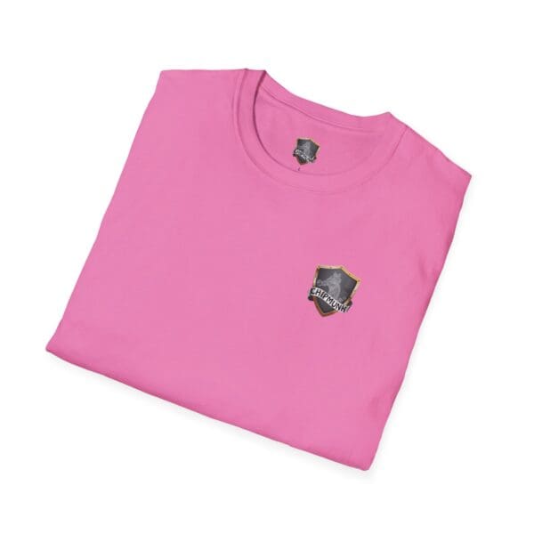 A folded pink t-shirt featuring a shield-shaped logo on the front with the design promoting childhood cancer awareness.