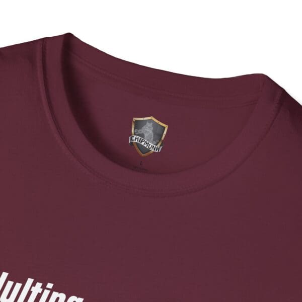 A close-up of the maroon Adulting 1-Star Review T-Shirt with a Chipmunk brand logo tag on the neck seam, showcasing partially visible white text.