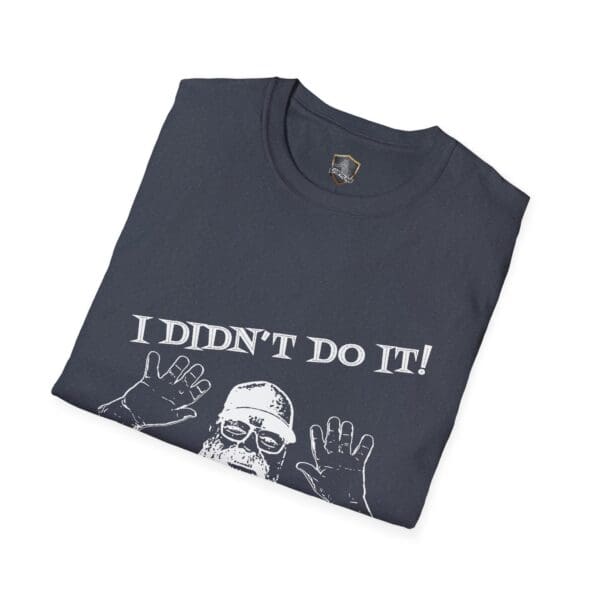 Dark t-shirt, neatly folded, featuring a white illustration of George the Roadie holding up hands alongside the phrase: "I Didn't Do It! I Was Framed!!!