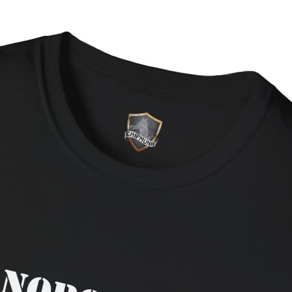 Close-up of a black "Nobody Is Perfect" Statement T-Shirt featuring a small "Chipmunk" logo and a shield design on the inside collar.