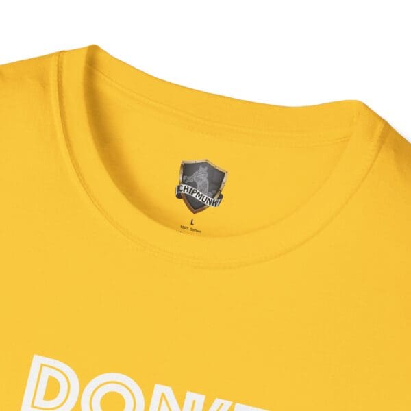 Close-up of a yellow Don't Be A... Tee featuring a "CHIPMUNK" label inside the collar and part of the word "DON'T" printed in white on the front.