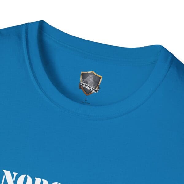 Close-up of a blue "Nobody Is Perfect" Statement T-Shirt with a label featuring a shield design and the word "CHIPMUNK." The text on the shirt reads "NOR.