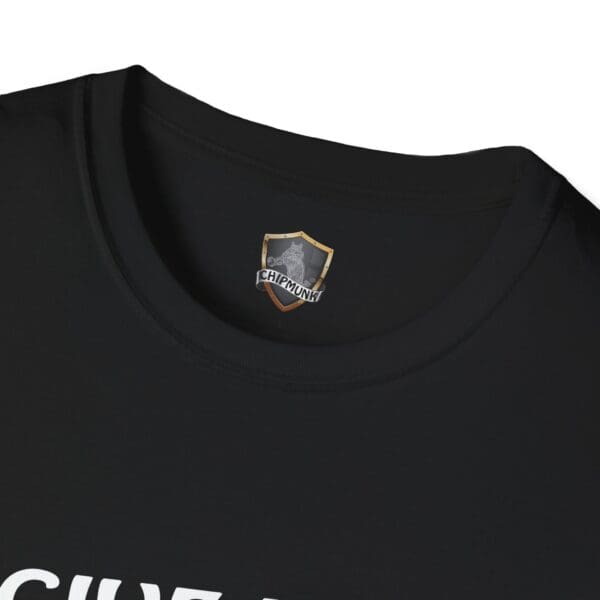 A close-up view of the neckline of a black "Give Me The Tips T-Shirt" featuring a gray and gold chipmunk logo tag inside, with the upper portion of white text partially visible at the bottom.