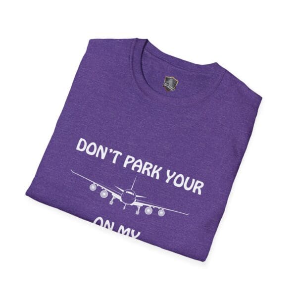 A folded purple t-shirt featuring the text "DON'T PARK YOUR" above and "ON MY" below an illustration of an airplane, identified as the "Don't Park Your Plane On My Dingy T-Shirt.