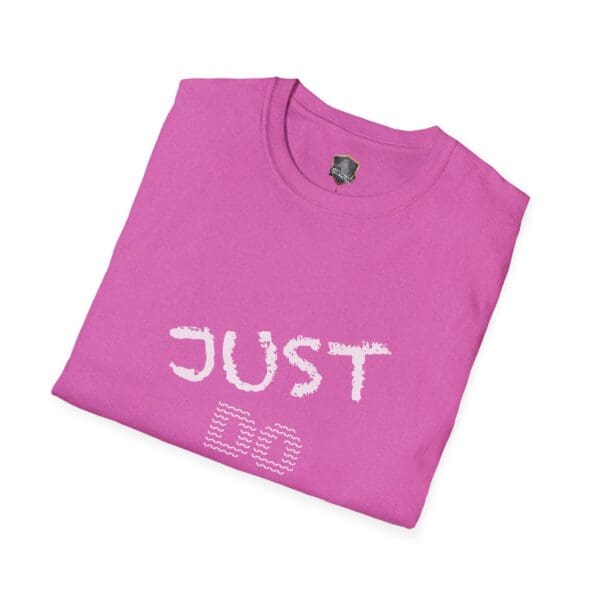 A folded pink t-shirt with the text "JUST DO YOUR JOB!" printed on the front in white letters.