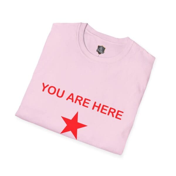 Folded pink Guiding Star Tee Shirt with "YOU ARE HERE" printed in red above a red star.