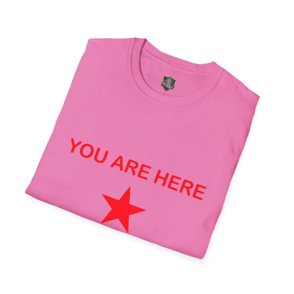 A folded pink Guiding Star Tee Shirt featuring the text "YOU ARE HERE" in red above a red star.