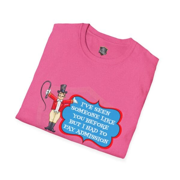 Folded pink Admission T-Shirt featuring a cartoon ringmaster with a whip, and text that reads, "I've seen someone like you before but I had to pay admission.