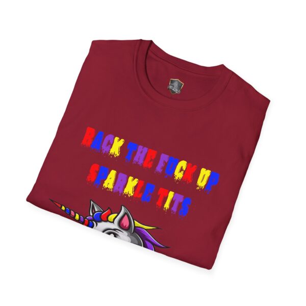 A folded red T-shirt featuring vibrant text that says, "Back the fuck up, sparkle tits," alongside a partial unicorn graphic, known as the Colorful Angry Unicorn Tee.