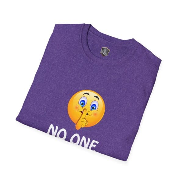 Folded purple No One Cares T-Shirt adorned with an emoji holding a finger to its lips above the text "NO ONE.