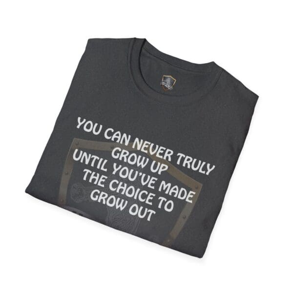 A folded black 'You Can Never Truly Grow Up' T-shirt with the text: "You can never truly grow up until you’ve made the choice to grow out.