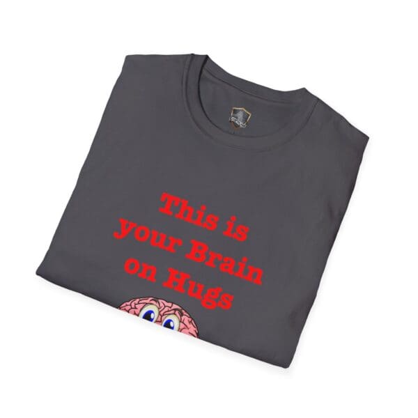 Gray folded t-shirt featuring the product name, "This is Your Brain on Hugs T-Shirt," adorned with red text saying "This is your Brain on Hugs" and a cartoon brain illustration peeking from the bottom.