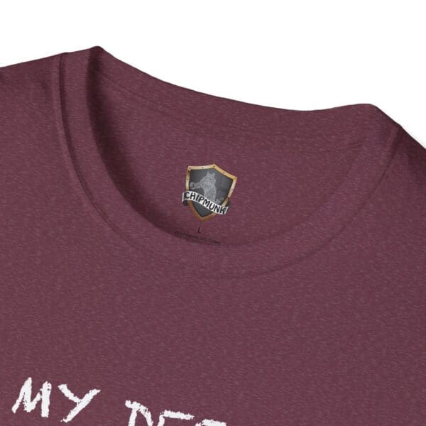 Close-up of a maroon neckline with the Unsupervised Mischief T-Shirt label.