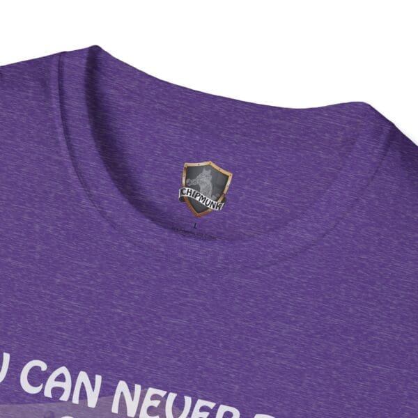 Close-up of a purple 'You Can Never Truly Grow Up' T-shirt with the Chipmunk logo on the inside label.