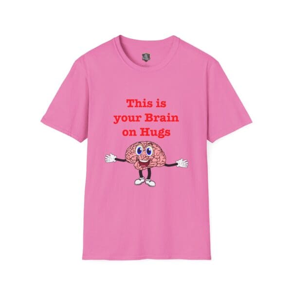 Pink t-shirt featuring an illustration of a smiling brain with arms, legs, and eyes, accompanied by the text: "This is Your Brain on Hugs.