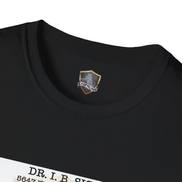 Close-up of the Laughter T-Shirt, a black tee showcasing a shield emblem logo at the neckline with partially visible text that reads "DR. I.B. SIG" at the bottom.