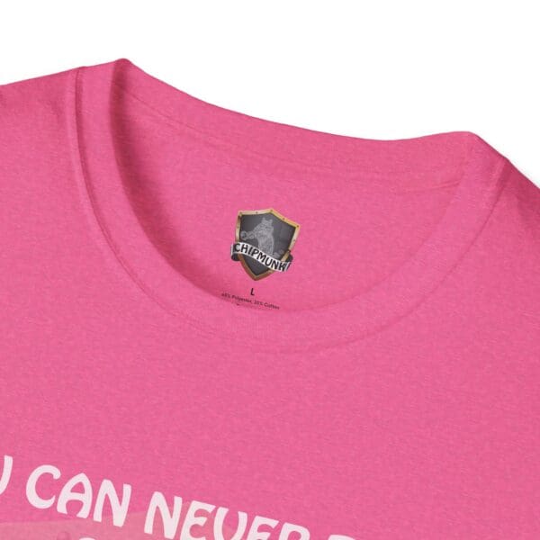 A close-up of the neckline on a pink 'You Can Never Truly Grow Up T-Shirt' features a black and gold Chipmunk brand logo tag.