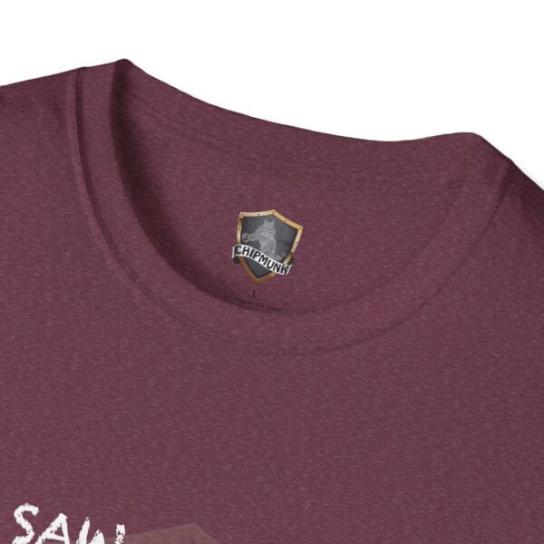 Close-up of the I Saw T-Shirt in maroon, showcasing a "Chipmunk" shield logo inside near the neck. The front features a partial graphic with the text "SAV.