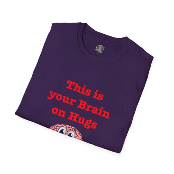 Folded T-shirt in purple featuring a cartoon brain graphic and the text "This is Your Brain on Hugs" in red.