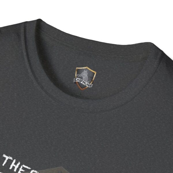 Close-up of the neckline of a "There's a First for Everything... Except Impressions!" T-shirt in dark gray, featuring a "Chipmunk" logo on a shield tag. The text below is partially visible.