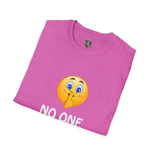 Folded pink t-shirt featuring a shushing emoji with the phrase "No One Cares" printed below it.